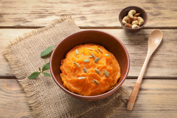 Bowl with mashed sweet potato on wooden background