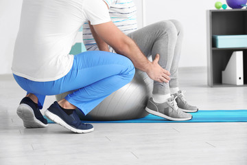Physiotherapist working with senior patient in modern clinic