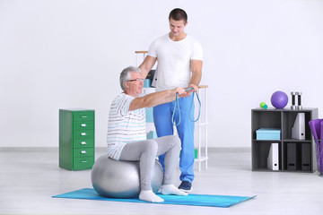 Physiotherapist working with senior patient in modern clinic © Africa Studio