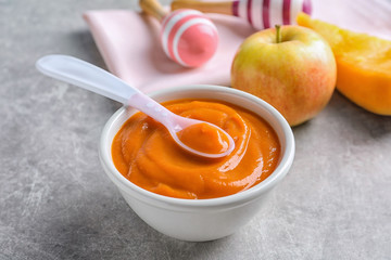 Ceramic bowl with baby food on table