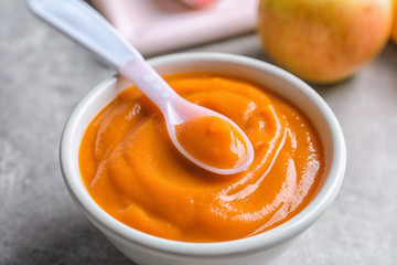 Ceramic bowl with baby food on table