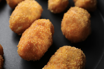 Delicious salmon croquettes on frying pan, closeup
