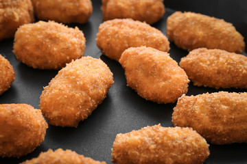 Delicious salmon croquettes on frying pan, closeup