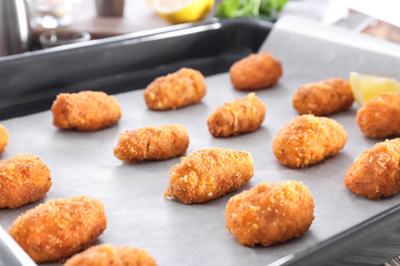 Delicious salmon croquettes in baking tray, closeup