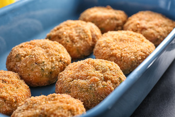 Delicious salmon patties in baking dish, closeup
