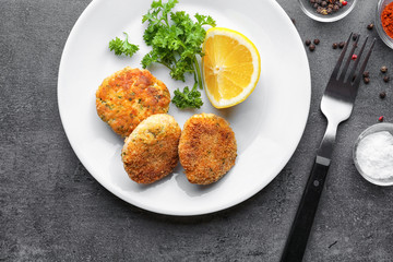 Plate with delicious salmon patties on table