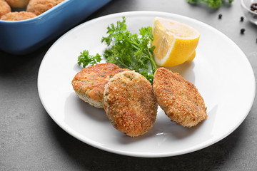 Plate with delicious salmon patties on table, closeup