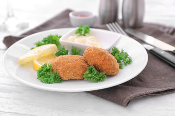 Plate with delicious salmon patties on table, closeup