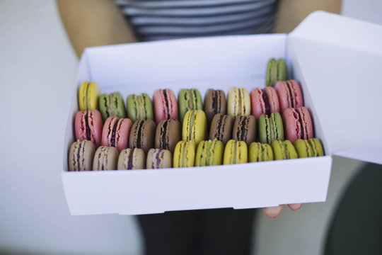 Woman holding a box full of macaroons