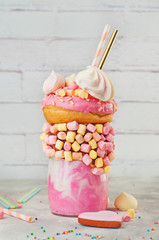 Raspberry freak shake topping with donut on grey background