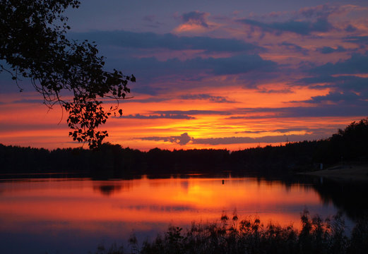 Beautiful sunset with orange-blue clouds during the evening by the water
