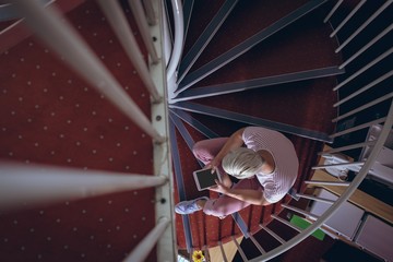 Overhead of man using digital tablet on staircase