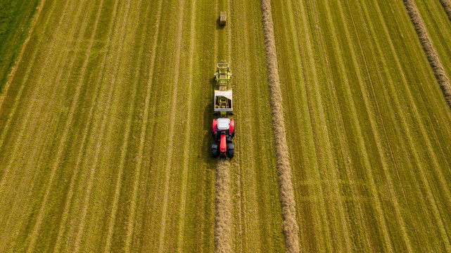 Trecker mit einer Strohpresse bei der Arbeit. 