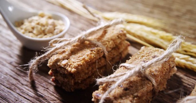 Granola bars tied with string and grains on spoon 