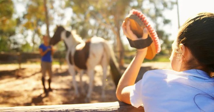 Girl waving hand to her mother in ranch 