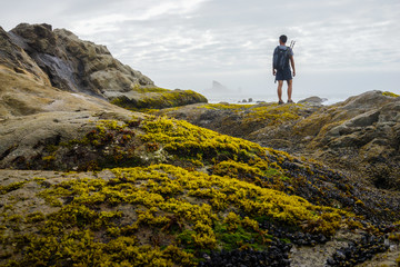 Fototapeta premium A hiker is standing and looking out to sea stack.