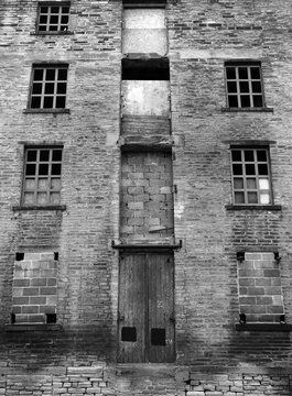 abandoned disused old derelict factory or mill building with broken windows
