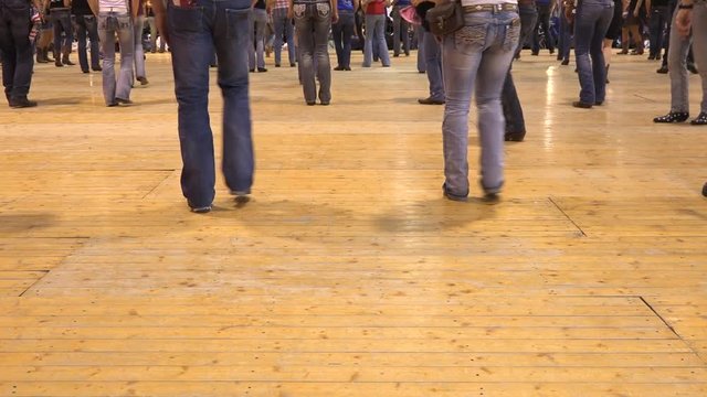 Legs moving together at American horse festival. Music tradition jeans boots and flag. People dancing cowboy line dance at a folk country event, USA style