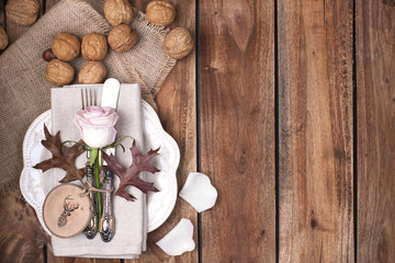 Fototapeta na wymiar The wooden table is decorated with an autumn decor and flowers, cutlery