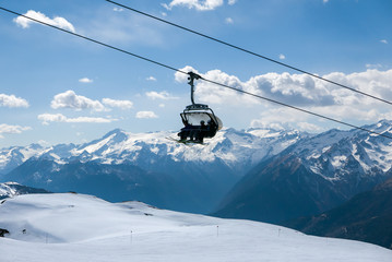 Fototapeta na wymiar Skiers using ski lift in popular ski resort