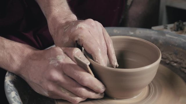 Hands of the master potter and vase of clay on the potter's wheel close-up. Master crock man. Twisted potter's wheel.