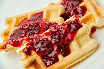 Crispy wafers poured with raspberry jam. Macro photo.