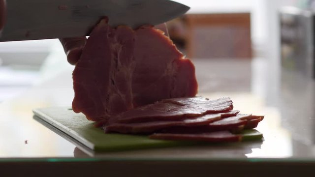 Hands Of Elderly Man Cut A Piece Of Meat On The Table