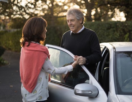 Senior Couple Holding Hands Near The Car