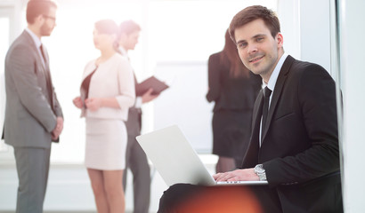 Fototapeta premium concept of the Internet: young smiling businessman with laptop s