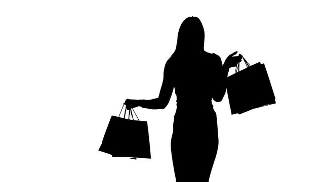 Woman packages in hands posing for cameras. Silhouette. White background. Slow motion