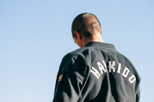 Man facing back during a martial arts training against blue sky background