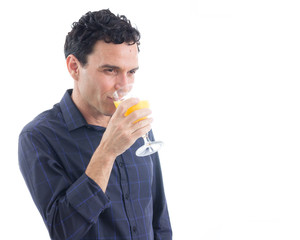 Fototapeta premium Healthy man is drinking orange juice. The person is wearing dark blue social shirt. Isolated..