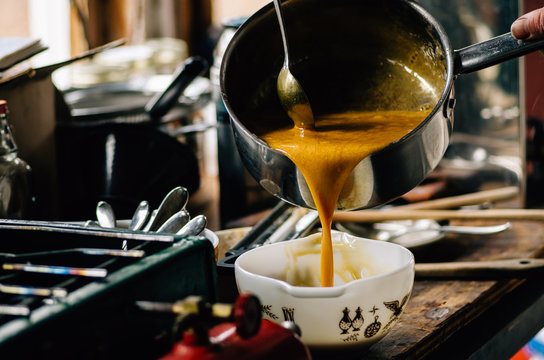 pouring boiling syrup into bowl to make maple candy