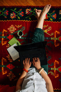 Woman sitting on the floor and working on a laptop