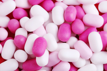Pink and white candies gum on a red table