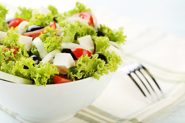 Vegetable salad in bowl with fork and napkin