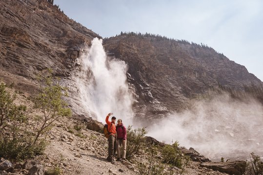 Hiker Couple Standing Near Waterfall