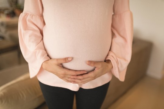 Pregnant woman standing in living room