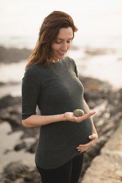 Pregnant woman holding a round shell
