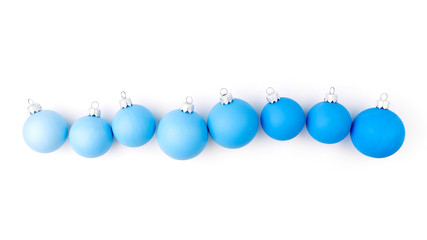 Horizontal border of blue Christmas balls on wite background. Flat lay, top view