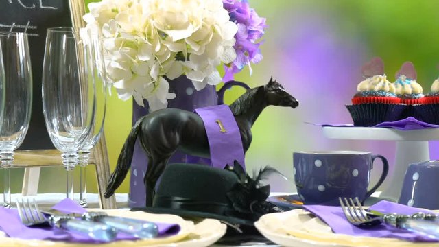 Horse racing Racing Day Luncheon fine dining table setting with small black fascinator hat, decorations and champagne, close up panning.