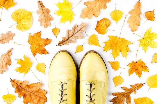Autumn composition. Pattern made of autumn  leaves and stylish shoes on white background. Flat lay, top view