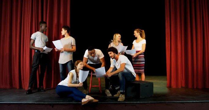 Actors discussing their scripts on stage 