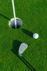 Golf club and ball on the green course. Close up. Top view. Sport, relax, recreation and leisure concept
