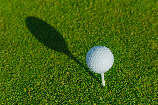 Golf ball on the green course. Close up. Sport, relax, recreation and leisure concept