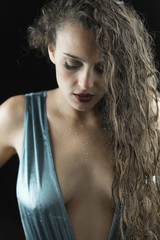 Fototapeta premium Wet look from a cute woman, studio in black background, wet skin and hair, wear blue shine one piece swimsuit