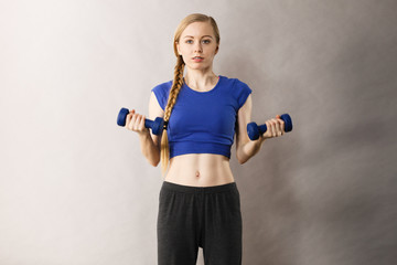 Fototapeta na wymiar Teenage woman working out at home with dumbbell