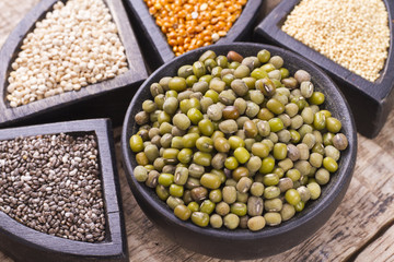 super food in wooden containers, amaranth, chia, quinoa and red millet