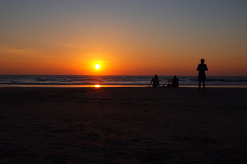 Fototapeta premium silhouettes of people on the beach at sunset