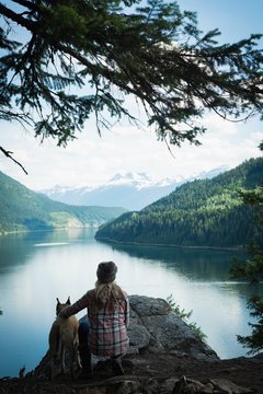 Woman with dog relaxing near river